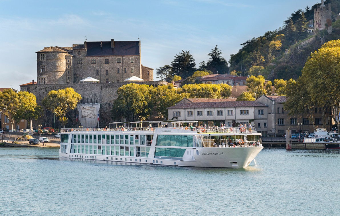 Luxury river ship sailing past a quaint town along the Rhône River in France