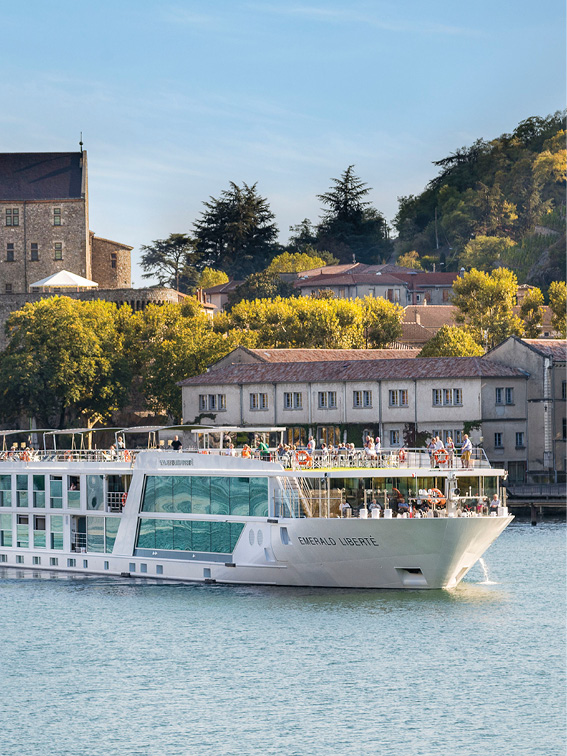 Luxury river ship sailing past a quaint town along the Rhône River in France