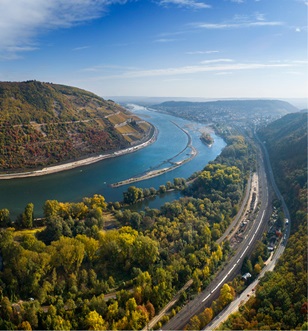 Bend of the Rhine river with lush green landscapes either side, showcasing the vineyards of the wine region