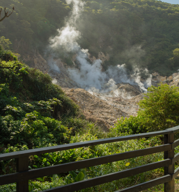 A smoking volcano surrounded by greenery in soufriere Saint Lucia. 
