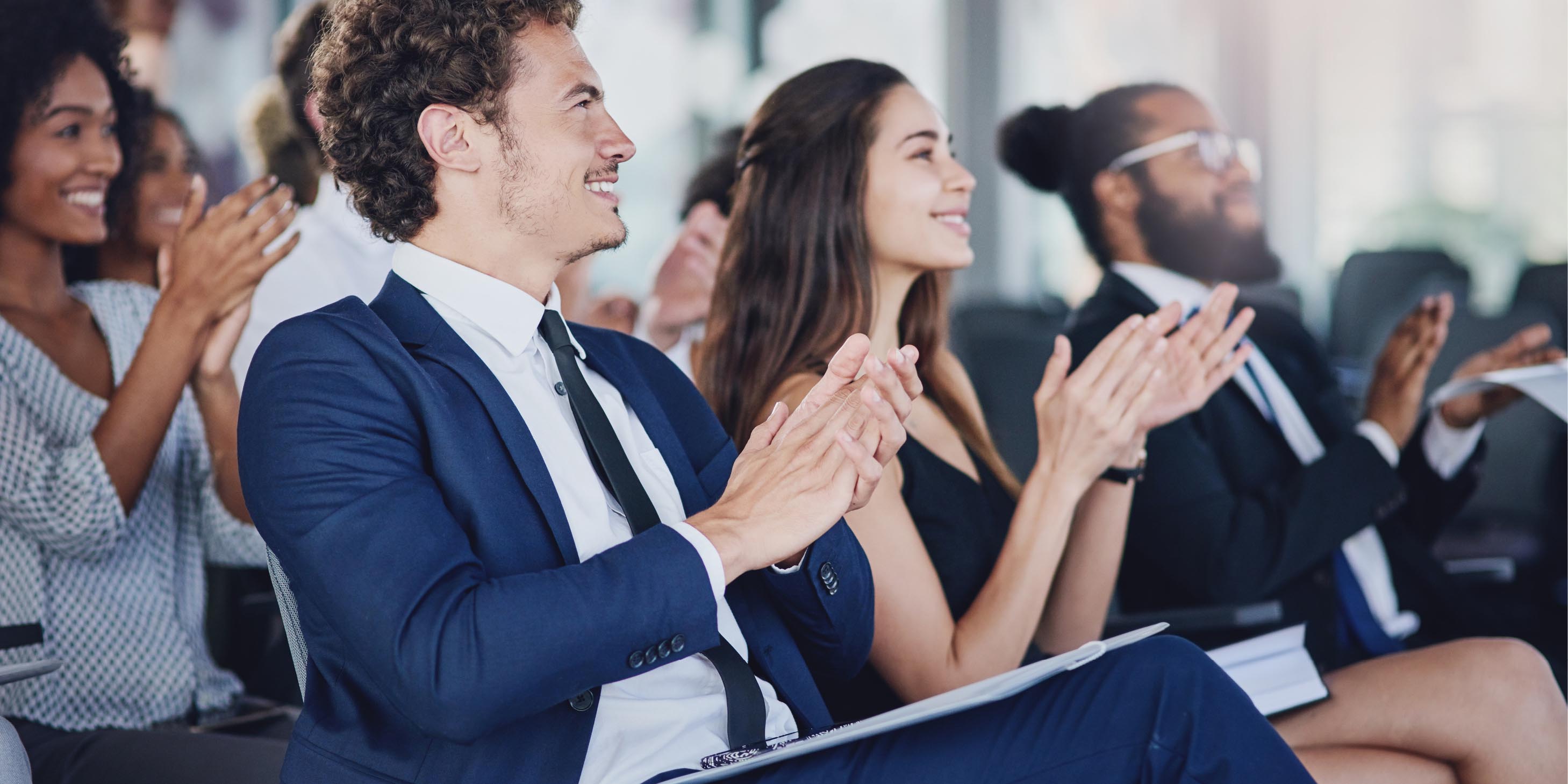Group of people wearing business attire clapping