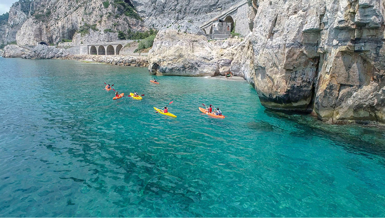 Group of people sea kayaking in crystal blue water