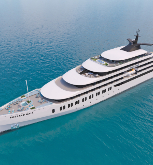 a large and luxurious cruise ship sails along a serene body of rippling water 