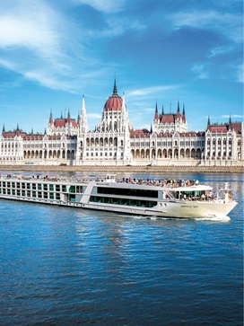 Luxury river ship sailing along the Danube River past the Hungarian Parliament Building in Budapest