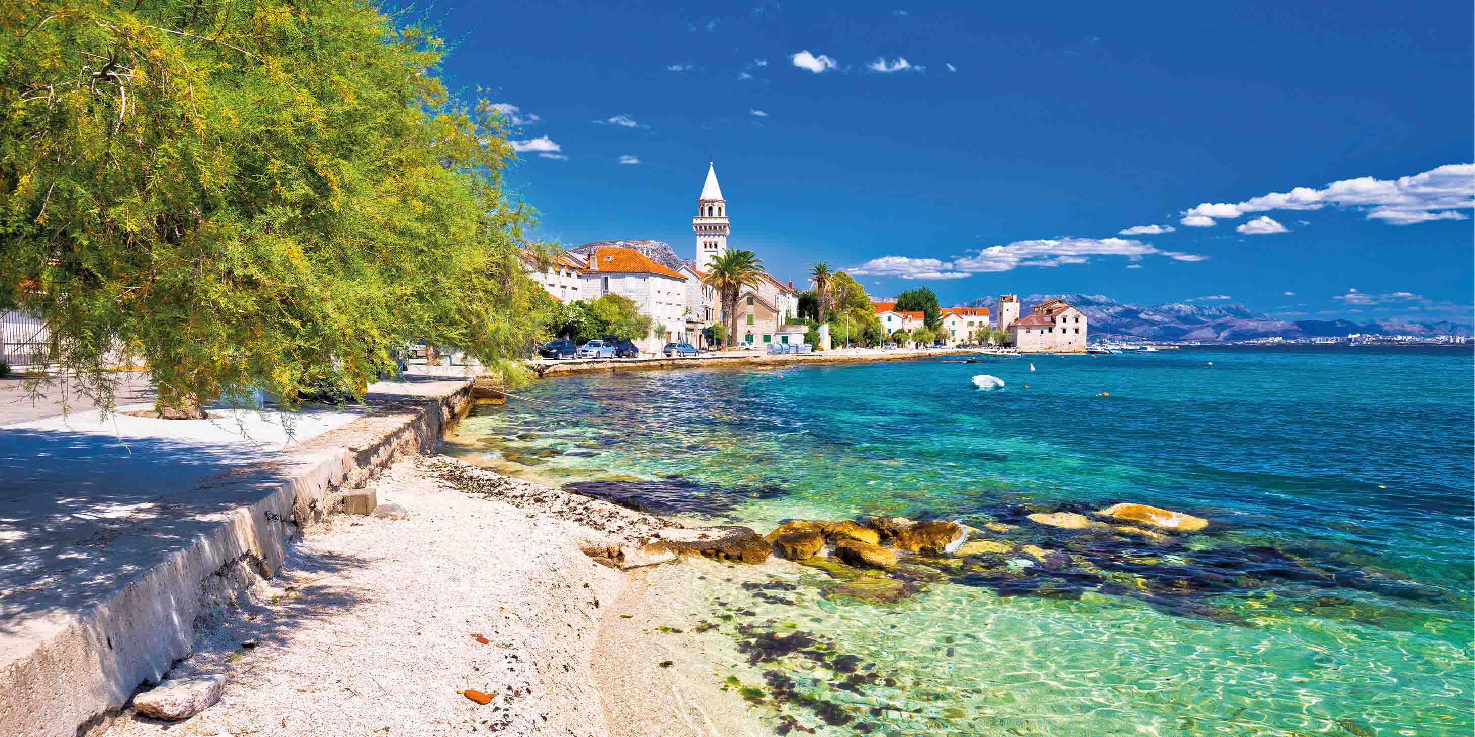 A coastal town in Croatia on a bright sunny day, along the shores of the crystalline waters