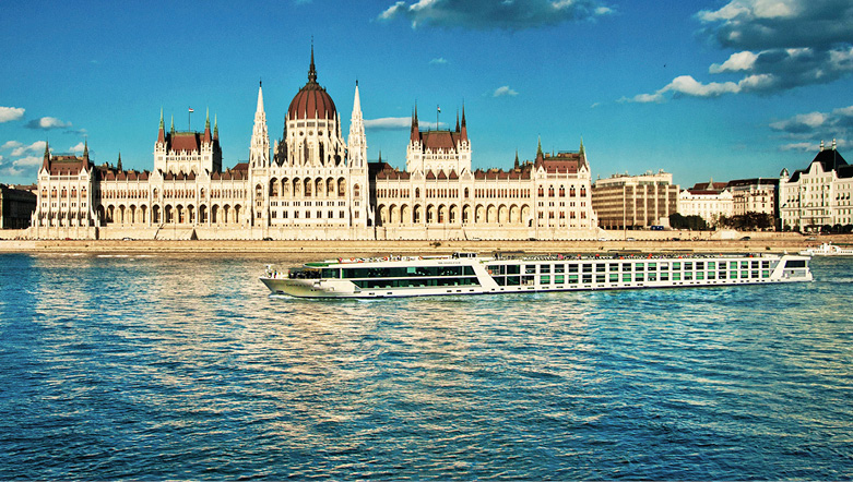 An Emerald Cruises luxury river ship sailing down the Danube in Budapest in front of the Parliament building