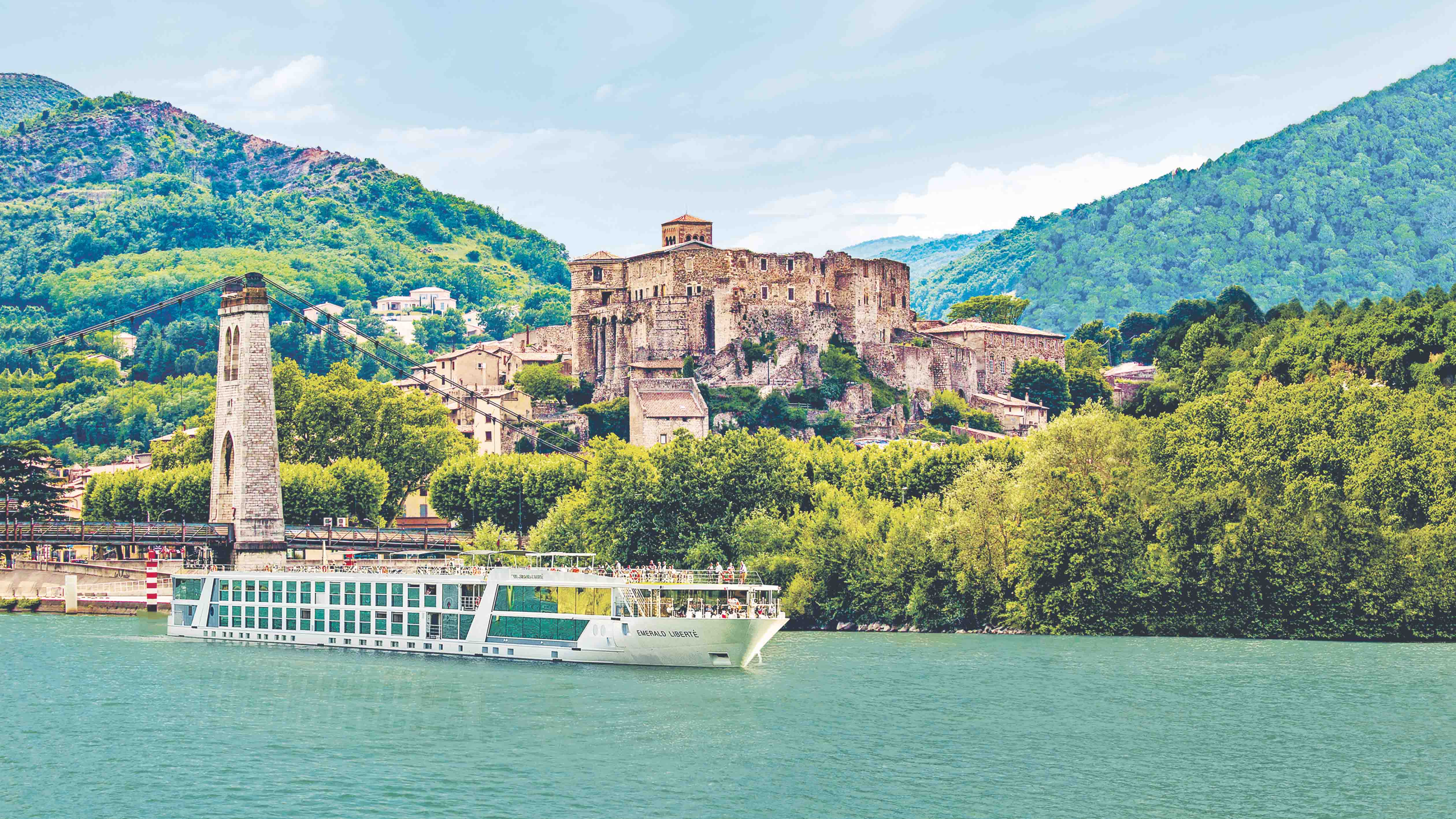 Luxury river ship sailing the Rhône River in the South of France passing a rustic castle
