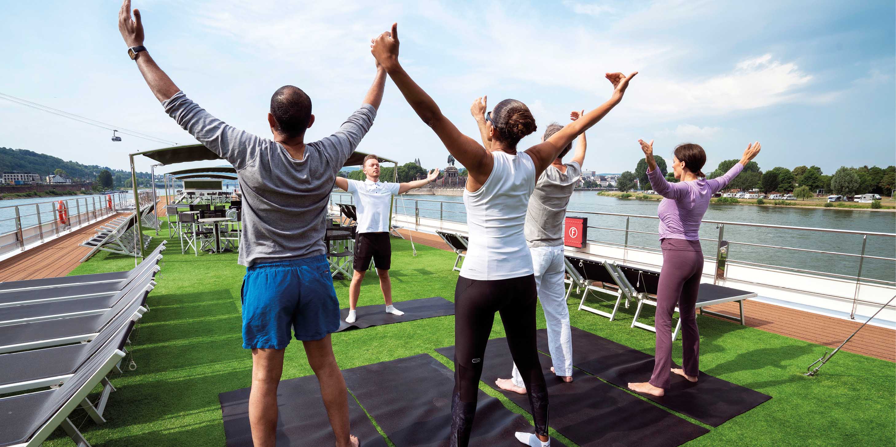 Guests taking part in a yoga session on the Sun Deck of a luxury river ship in Europe