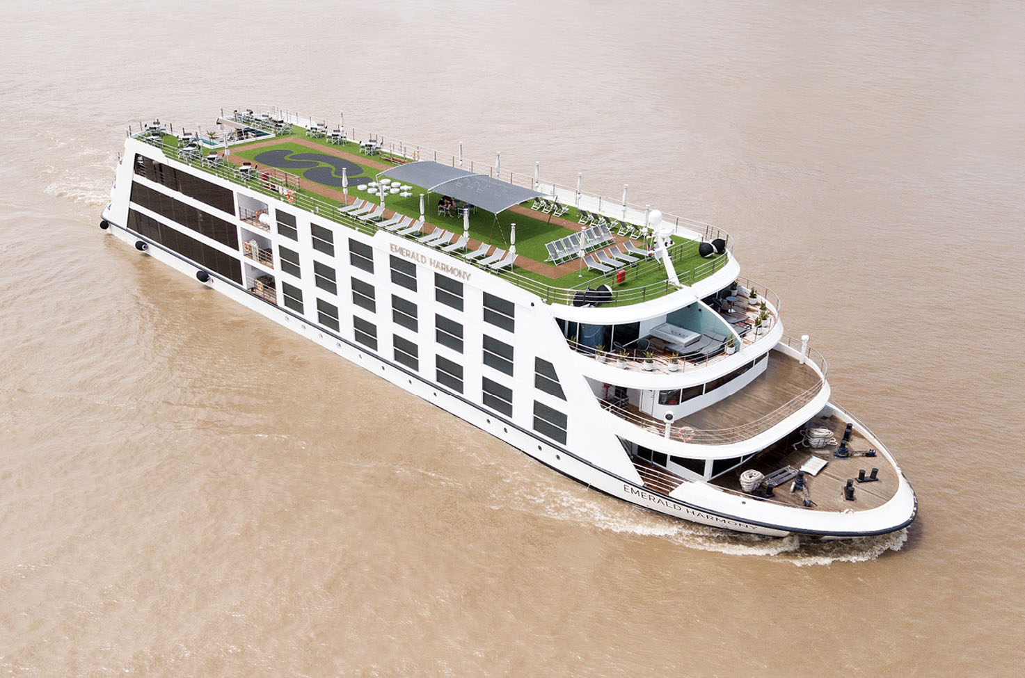Emerald Harmony luxury cruise ship sailing the Mekong River, with bright blue sky and trees in the background