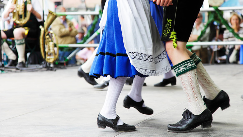 Bavarian couple dancing wearing traditional clothes