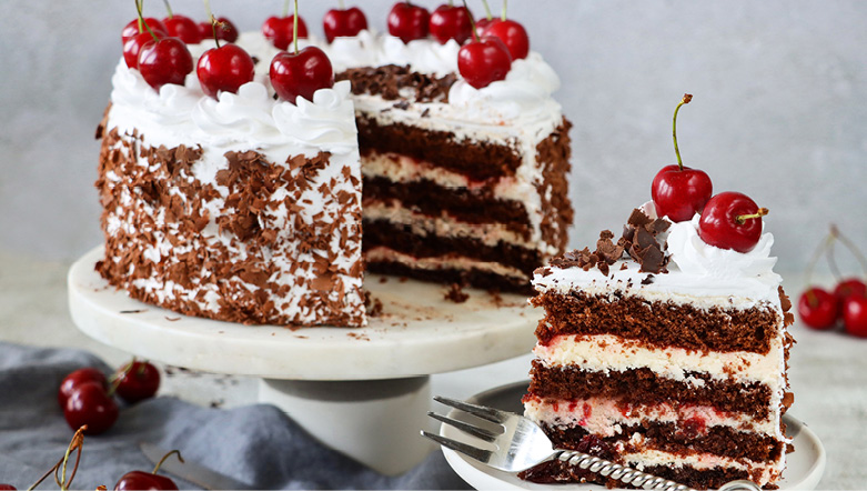 A slice of German Black Forest gateaux with cherries on top
