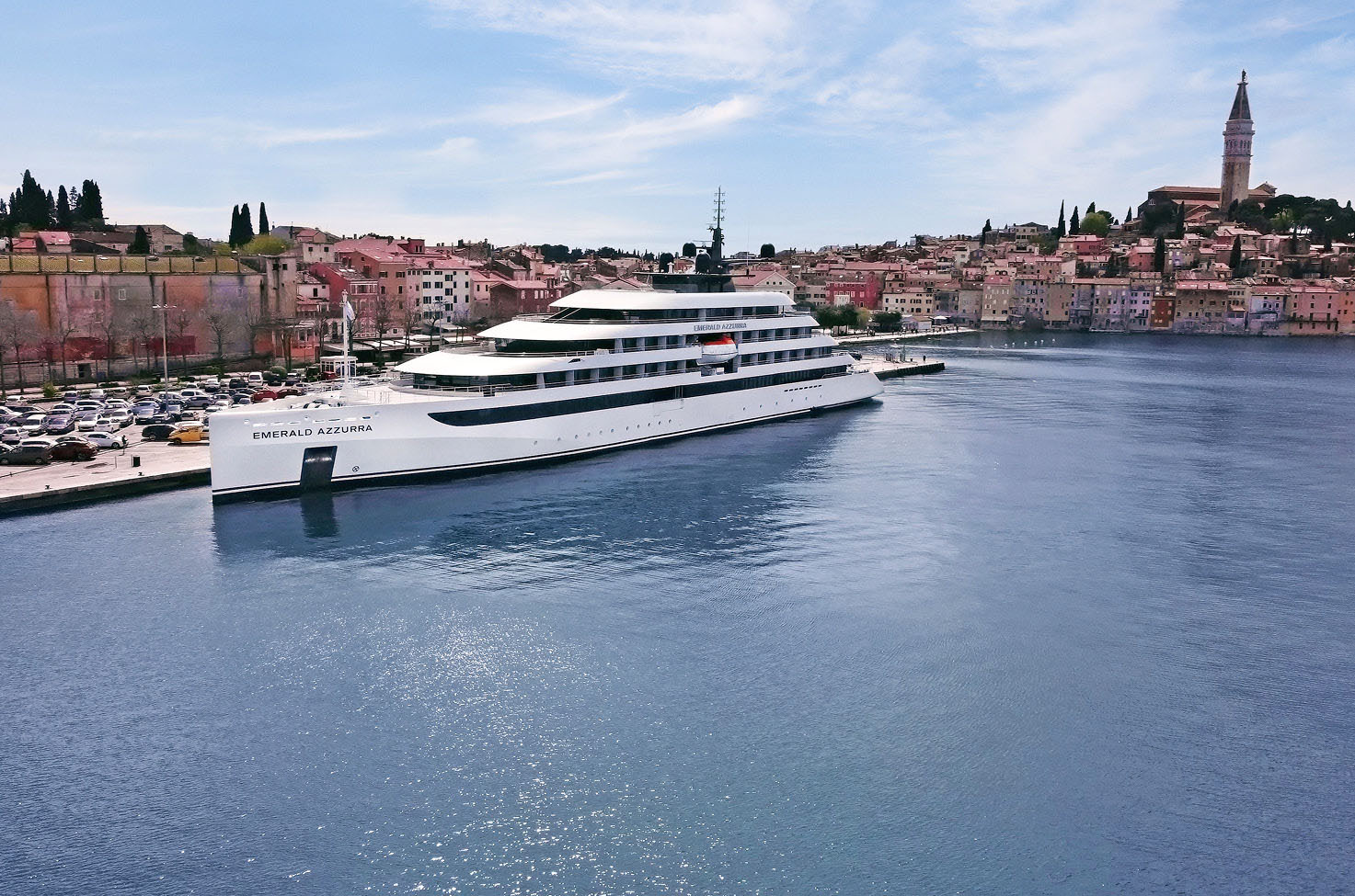 Luxury yacht docked in calm water next to a harbour in Rovinj near buildings