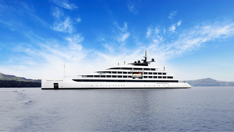 Luxury yacht sailing on a blue ocean with land seen in the distance