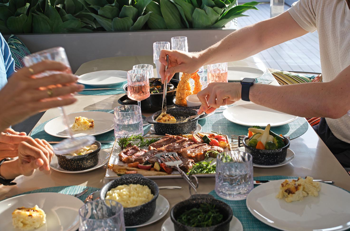 Flatbread loaded with toppings on a table next to a glass of white wine, with the bottle of wine just to the side