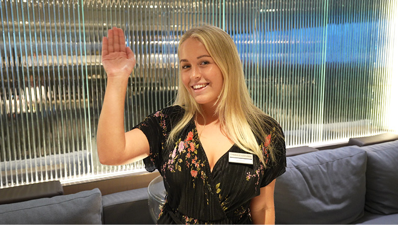 Smiling crew member waving on board an Emerald Cruises luxury yacht cruise